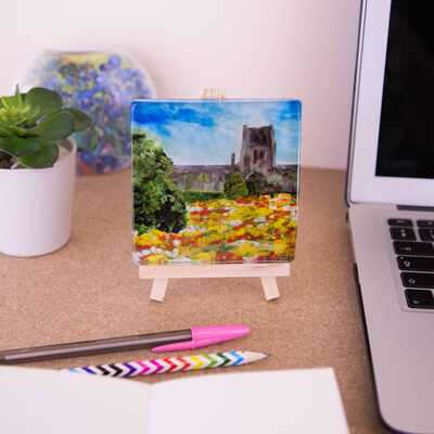 A mini easel holding a ceramic coaster of the painting of Durham Cathedral in bloom