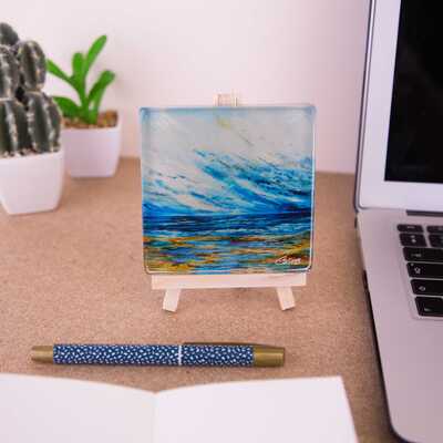 Mini easel holding a glass coater of Ebb tide on a desk