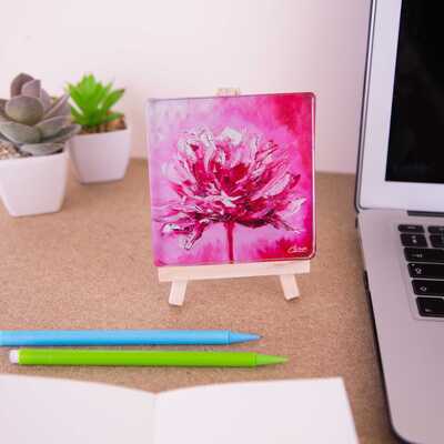 On a mini easel is a glass coaster of the painting Fleur rouge
