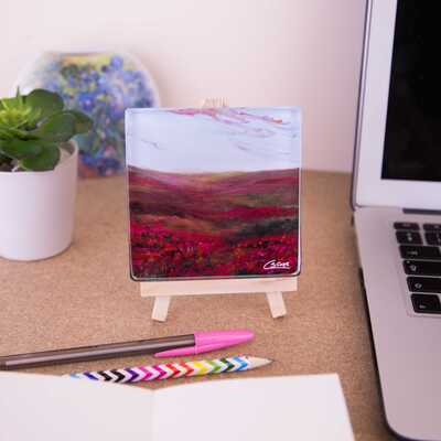 Mini easel holding glass coaster of moorland
