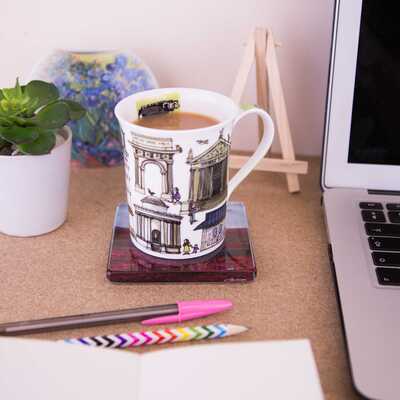 Cup on top of a glass coaster on a desk