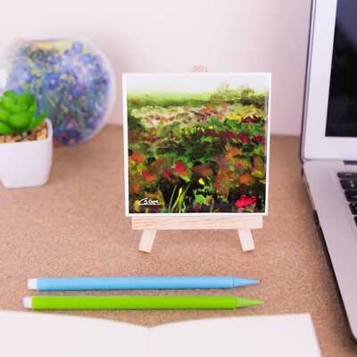 On a mini easel is a ceramic coaster with part of the painting 'Heathlands'