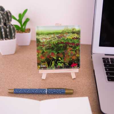 On a mini easel is a glass coaster showing a close up of the painting Heathlands