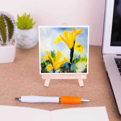 On a mini easel is a ceramic coaster of the painting Irises in the sunshine
