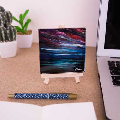 On a mini easel is a glass coaster of the painting Moontide