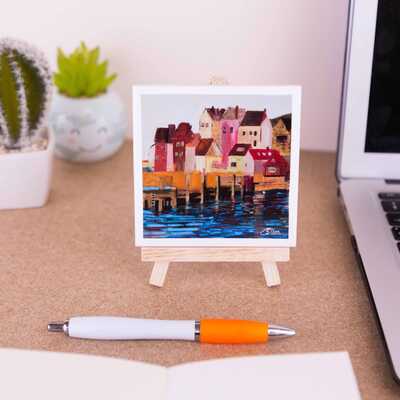 Mini easel holding a ceramic coaster of Whitby's pier and lifeboat station