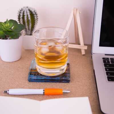 Glass coaster with Whisky tumbler on a desk - Whitby