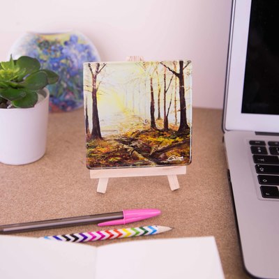 Mini easel holding a glass coaster of At the end of a golden day