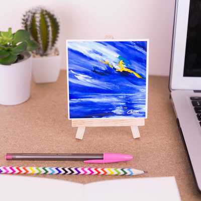 On a mini easel is a ceramic coaster of the painting Beginning
