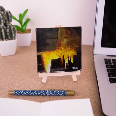 A mini easel holding a glass coaster of the painting Blast furnace