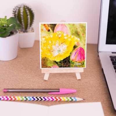 A ceramic coaster of the painting 'Sunshine' sits on top of a mini easel