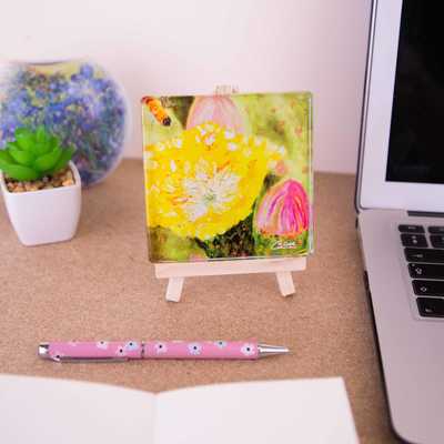 A mini easel holding a glass coaster of the painting Sunshine