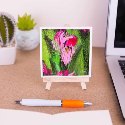 A mini easel holding a ceramic coaster of a flower from the painting Swaying in the breeze