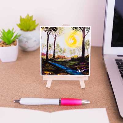 On a mini easel is a ceramic coaster of the painting Tumbling waters II