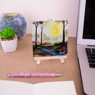 On a mini easel is a glass coaster of the painting Tumbling Waters II